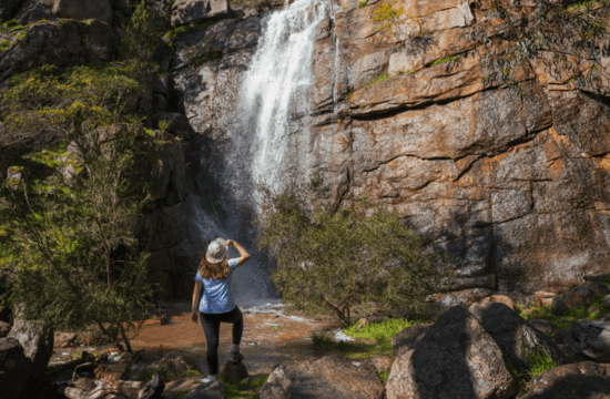 A person stands in front of Barry Falls in the Woolshed Valley