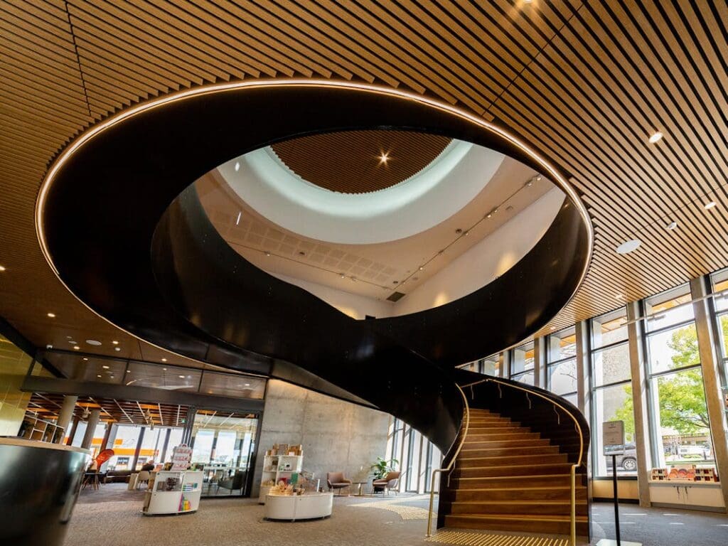 A large spiraling staircase can be seen inside Hyphen-Wodonga Library Gallery.