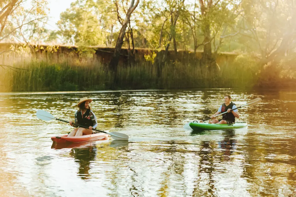 2 people on Canoes paddling down the river