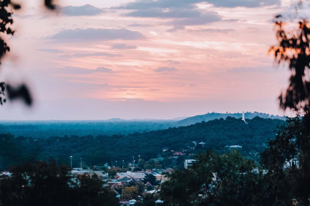 A view from Eastern Hill that looks across to the Monument Hill War Memorial. The hills take on a blue hue in the setting sun