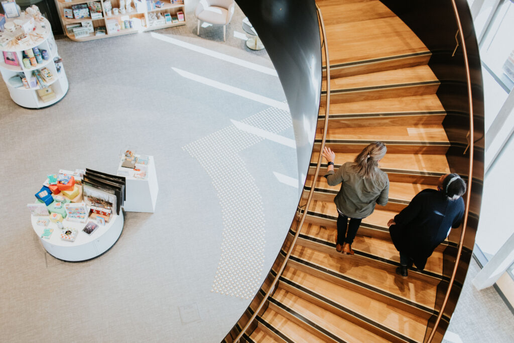Two poeple walking up the staircase at Hyphen - Wodonga Library Gallery