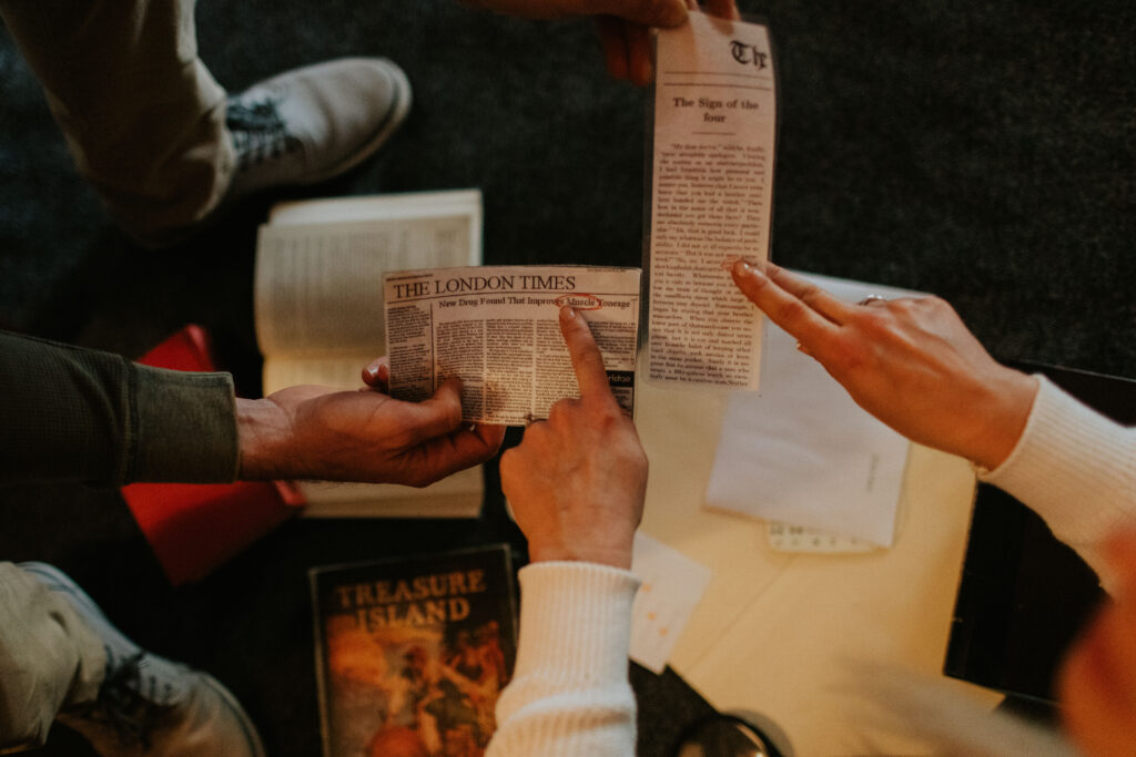 Fingers are pointing at newspaper clippings