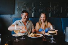 A man and a woman enjoying cocktails and food